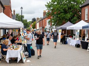 A bustling scene from Chapin's local arts festival with various art displays and community members.